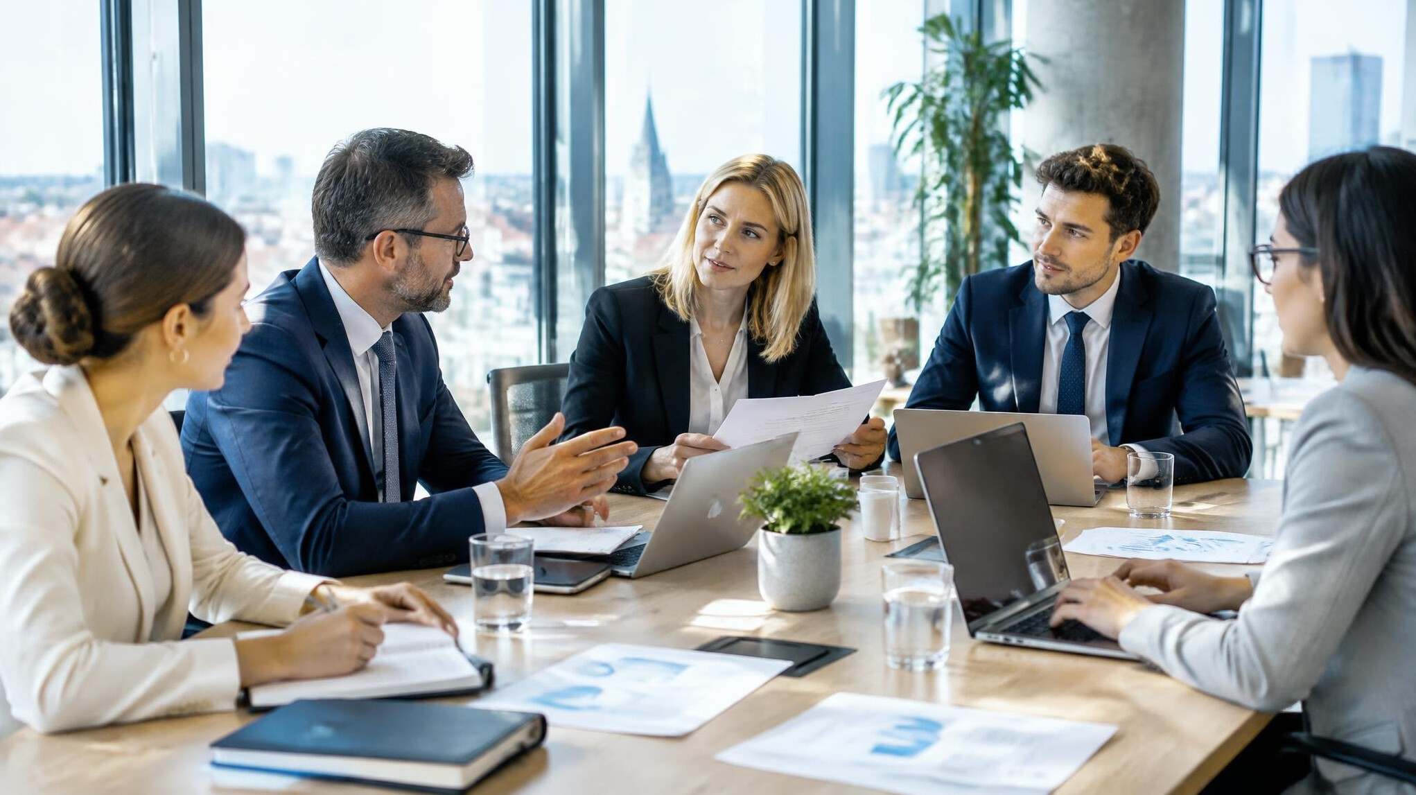 Business meeting around a table with documents and laptops